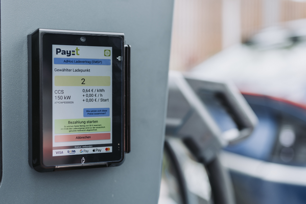 Nahaufnahme eines digitalen Zahlungsterminals an einer Ladestation für Elektrofahrzeuge.